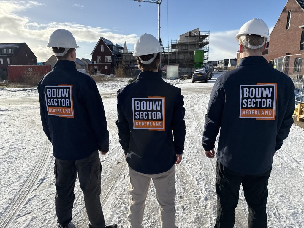 Drie medewerkers van Bouwsector Nederland met witte helm in een nieuwbouwwijk in aanbouw
